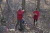 Two soil scientists work in the field, surrounded by trees